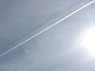 巻層雲に落ちる飛行機雲の影