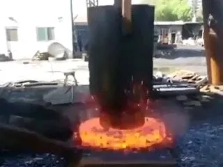 真っ赤に焼けた金属の塊に巨大ハンマーが落…