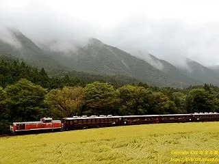 雲に包まれた山々を背に